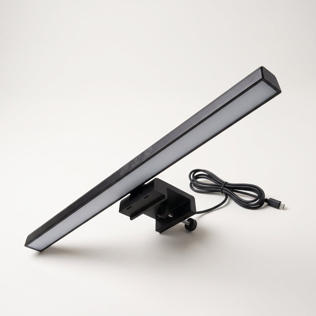 Black monitor light bar resting on its counterweight clip with the USB-C cable coiled beside it