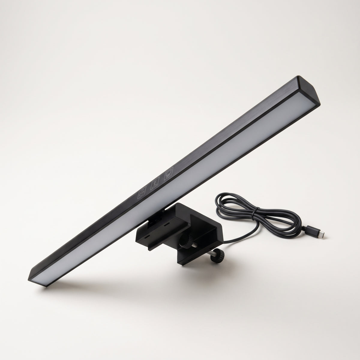 Black monitor light bar resting on its counterweight clip with the USB-C cable coiled beside it