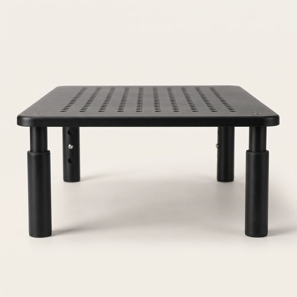 Monitor riser from a low angle, showing the height-adjustable legs and the ventilation holes