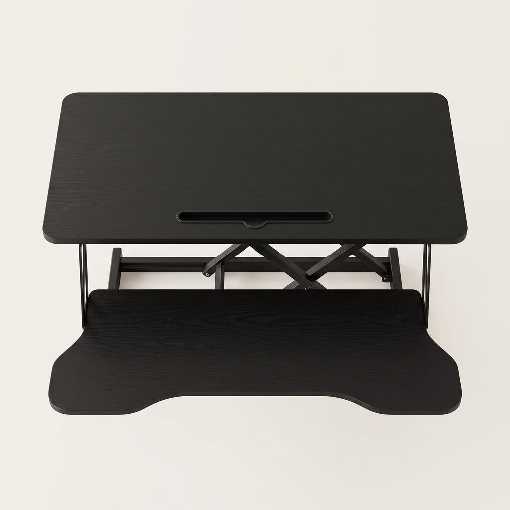 Sit-stand desk converter seen from the front with the contoured keyboard tray extended