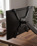 VESA adapter bracket fitted to the back of a monitor and attached to a desk arm